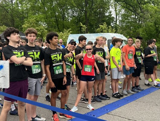Participants of the Forest Hills 5K stand at the starting line. 